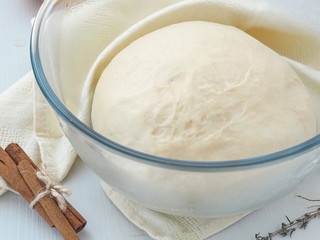 Cooking process. Leavened fresh dough in misted bowl. Preparing dough for cakes, pastries, buns or pizza. Close up image.