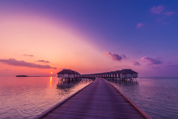 Fototapeta premium Luxury summer vacation background. Sunset over Luxury Maldives water villas