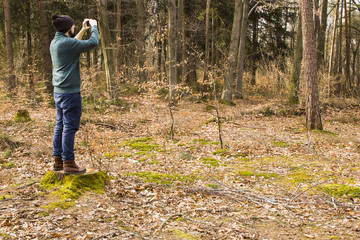 man taking photo with smartphone in the forest