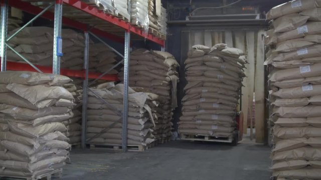 Loaders transport pallet with boxes on industrial warehouse