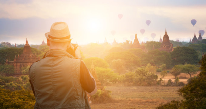 Young man traveller photographer take photo in old Bagan pagoda Mandalay Myanmar And beautiful landscape view of landmark Asian.