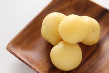 Multiple boiled new potato on wooden plate