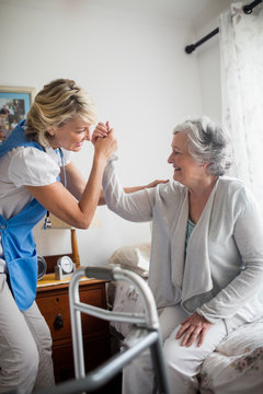 Nurse helping senior woman to stand up