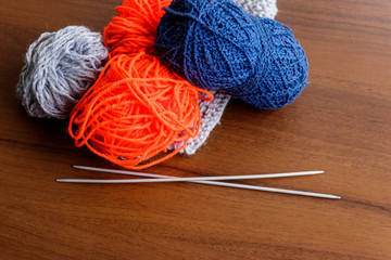 Woolen thread, knitting, knitting needles on wooden table