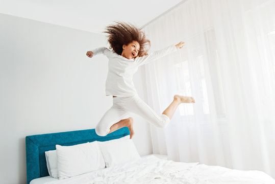 Cute girl jumping on the bed, happiness, joyful  