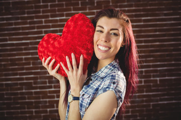 Woman holding a red heart plush