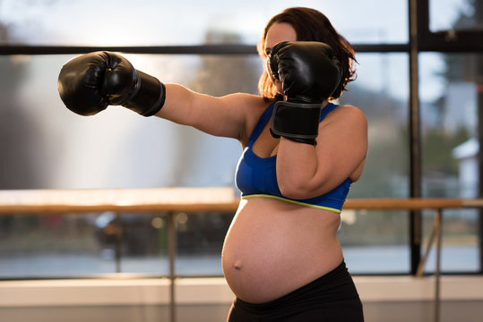Pregnant woman practicing boxing in living room