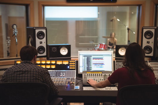 Audio engineers using sound mixer in recording studio