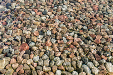 Sun reflection on the surface water above stones