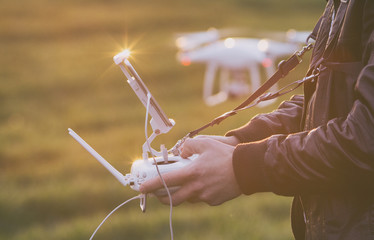 Farmer navigating drone above farmland - obrazy, fototapety, plakaty