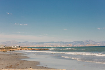 Caravan motorhome parked on the beach in front of the blue sea in a beautiful place of wild nature