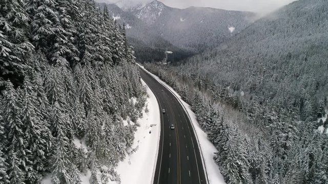 Snow Falling Aerial Over Mountain Valley Forest Road