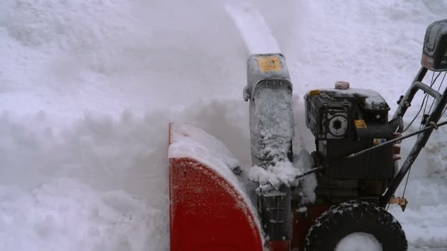 Man with a snow blowing machine working