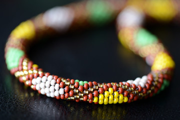 Ethnic style beaded necklace on a dark background close up