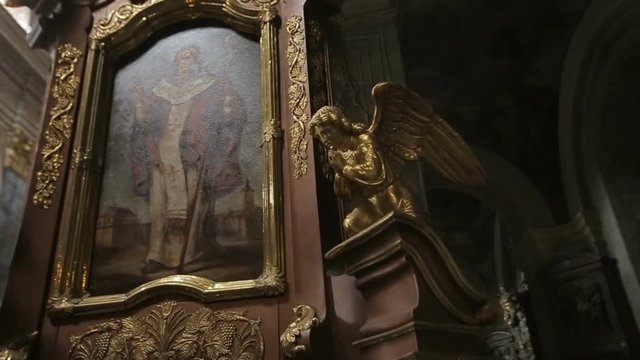 Gothic Church interior. Sculptures of golden angels are surrounding the icon. Historic architecture.