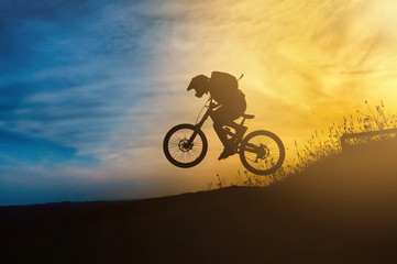 Obraz na płótnie Canvas Mountain biker jump at sunset