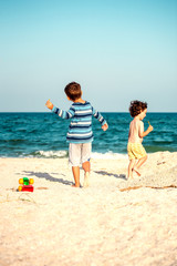 Fototapeta na wymiar Boys playing with sand on the beach.
