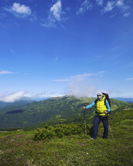 Summer hike in the mountains with a backpack and tent.