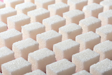 Cubes of refined white sugar the correct geometric shape on a pink background. Minimalistic abstract screensaver