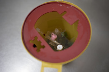 Yellow medical needle disposal waste container, syringe needle with red drop on the tip. Isolated. concept of pandemic, coronavirus, virus, disinfection, panic.