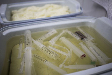 medical trays in a chemical solution for disposal of syringes