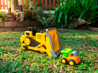 children baby toys tractor and truck in the beautiful garden forest playground  nature light flare outdoor