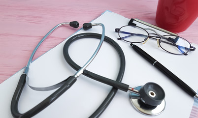stethoscope pen paper glasses cup of coffee