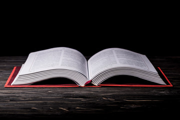 Open book on dark wooden table