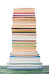 High tower of stacked books on table