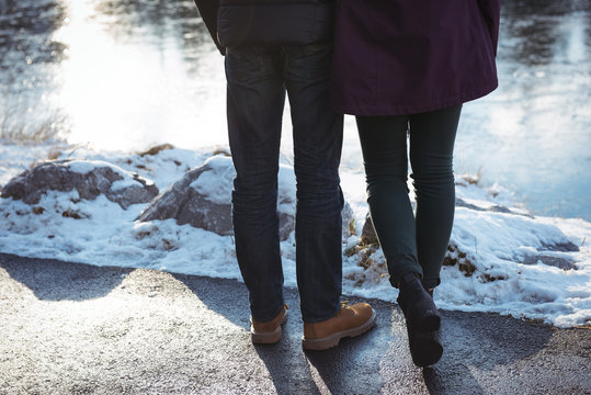 Romantic couple standing by river in winter