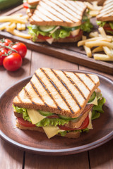 Club sandwich with tomatoes , cucumber , ham and cheese