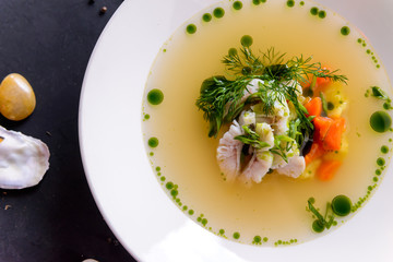 seafood soup in a white plate on a concrete background