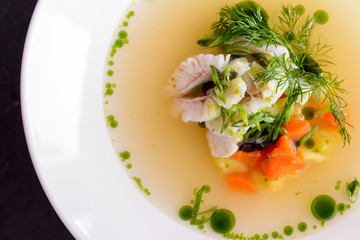 seafood soup in a white plate on a concrete background