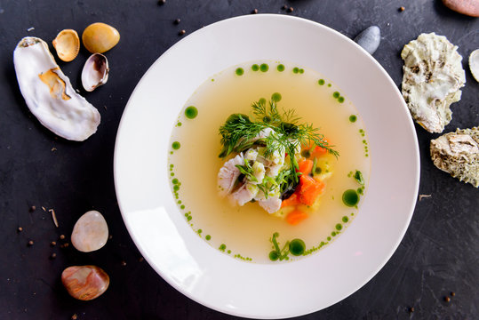 seafood soup in a white plate on a concrete background