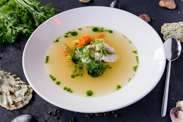 seafood soup in a white plate on a concrete background
