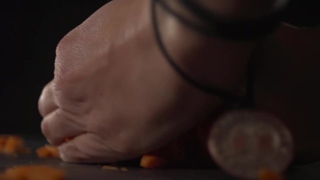 Sliced carrots are strewed against a dark background.