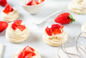 A small meringue Pavlova dessert with some strawberry slices . Top view. Pattern
