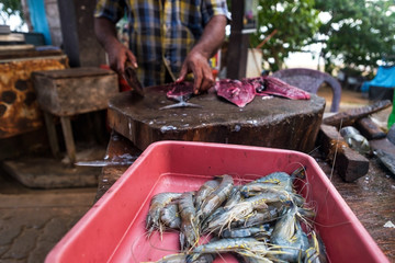 Man cutting fresh tuna with huge knife in Weligama In Sri Lanka. Prepare fresh fish in traditional way