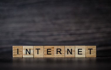 the word Internet, consisting of light wooden square panels on a dark wooden background