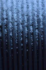 Coiled black wire with snow closeup abstract background. 