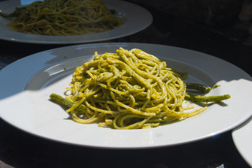 Plate of spaghetti with Ligurian pesto and green beans at the restaurant