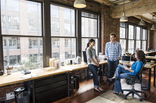 Mixed race group of people meeting to brainstorm an issue in a creative office.