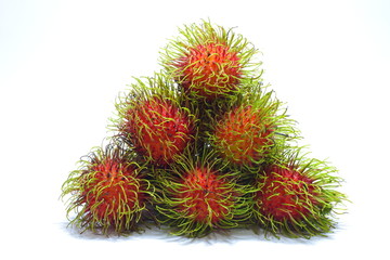 Many rambutans are stacked. On the white floor