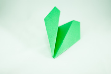Green paper plane on a white background, isolated. Concept (idea) of airlines, freedom, leadership, ecology, success, sustainability, and creativity