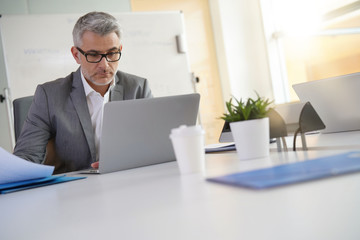 Businessman in office working on laptop