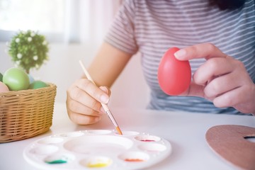 Obraz na płótnie Canvas Woman painting Easter eggs at home. family preparing for Easter. Hands of a girl with a easter egg