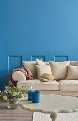 specious blue living room and cream armchair with pillows. Modern home decoration and middle tame interior decor.