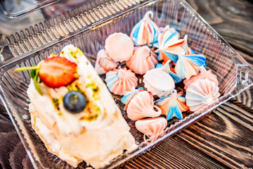 Slice of Swiss roll and colorful meringue kisses