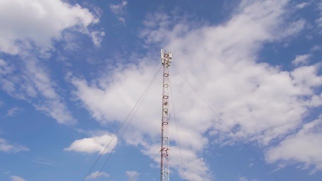 GSM or CDMA Antenna on a blue sky background, timelapse.
