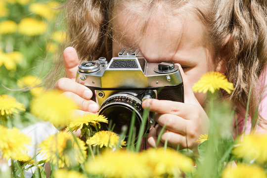 Little girl photographs in nature, photographer